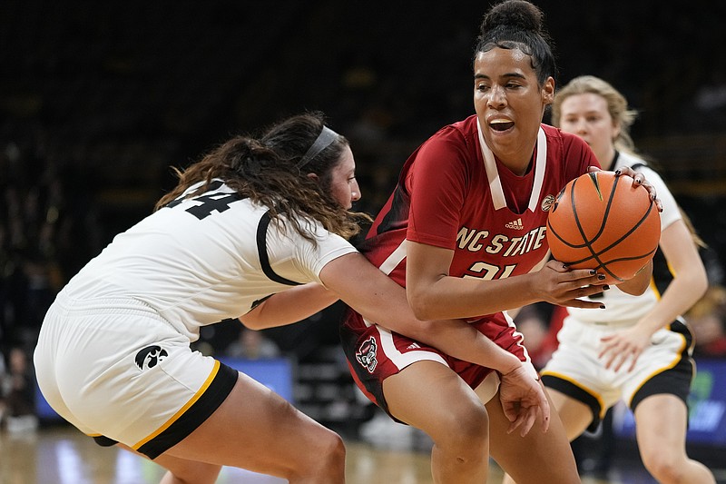 AP photo by Charlie Neibergall / N.C. State guard Madison Hayes, right, drives around Iowa forward McKenna Warnock during an ACC/Big Ten Challenge game on Dec. 1 in Iowa City. Hayes, who is from Chattanooga and was a prep star at East Hamilton, is in her second season at N.C. State after playing her freshman year at Mississippi State.