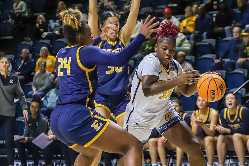 Staff photo by Olivia Ross / UTC's Raven Thompson heads toward the net while guarded by ETSU's Jakhyia Davis (24) and Jiselle Thomas during Saturday's SoCon game at McKenzie Arena.