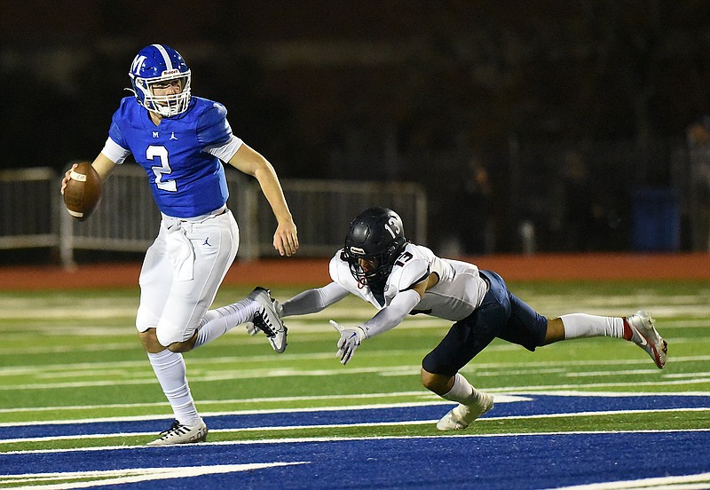 Staff photo by Matt Hamilton / McCallie quarterback Jérémy St. Hilaire looks for a receiver while avoiding a St. Benedict defender during a TSSAA Division II-AAA playoff game on Nov. 4, 2022, in Chattanooga.