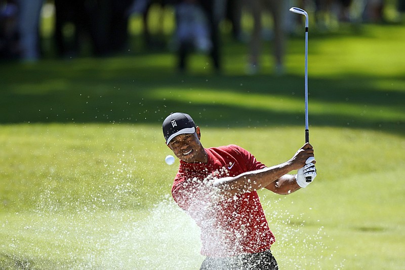 FILE -  Tiger Woods hits out of a greenside bunker on the 17th hole during the final round of the Genesis Invitational golf tournament at Riviera Country Club, Sunday, Feb. 16, 2020, in the Pacific Palisades area of Los Angeles. Woods is back at Riviera, this time with more on his plate than handing out the trophy in the Genesis Invitational. He returns to the PGA Tour for the first time since July. (AP Photo/Ryan Kang, File)