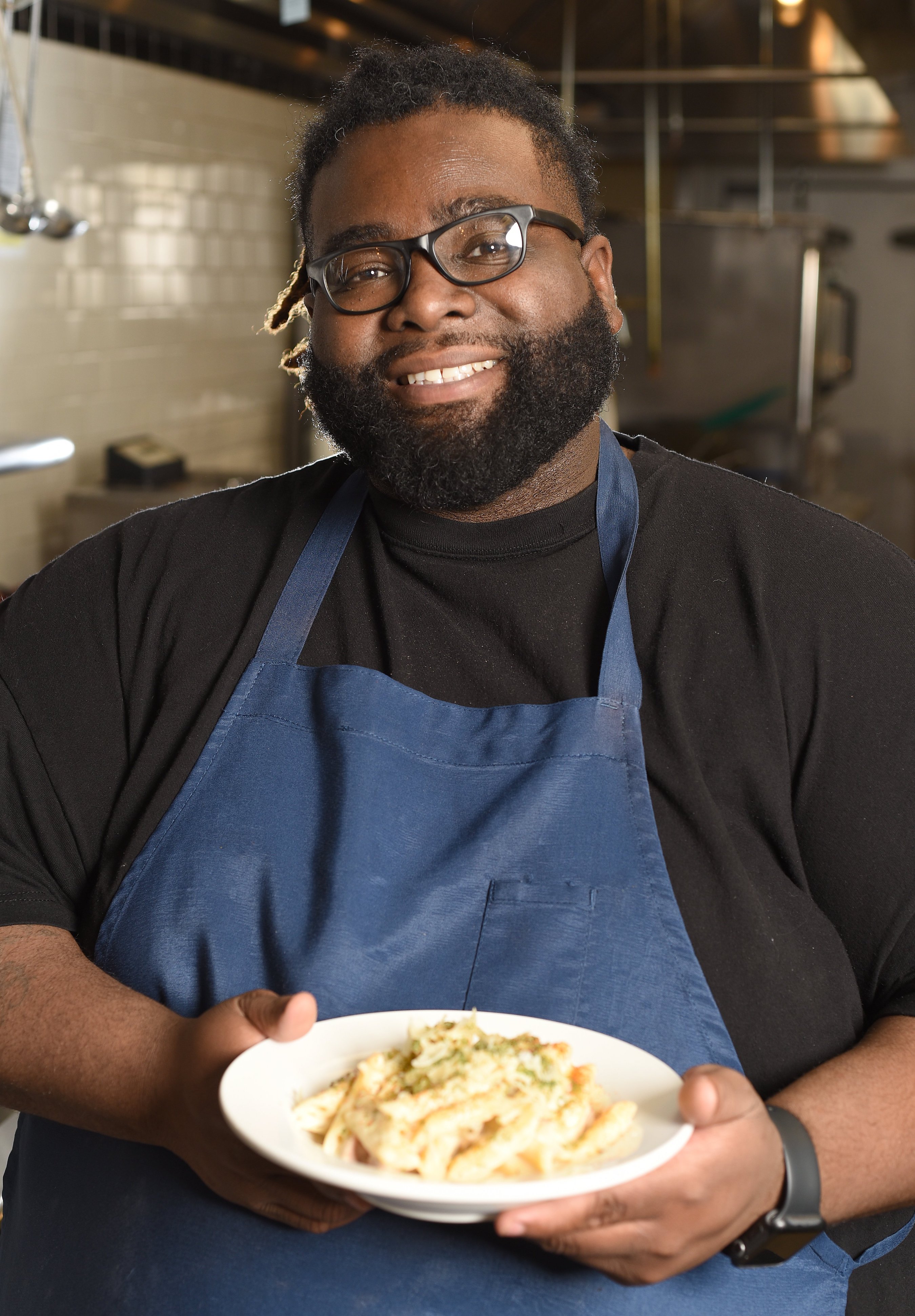 Staff Photo by Matt Hamilton / Chef Cornelius Lathan holds a plate of baked smoked chicken Alfredo at the Kitchen Incubator of Chattanooga.
