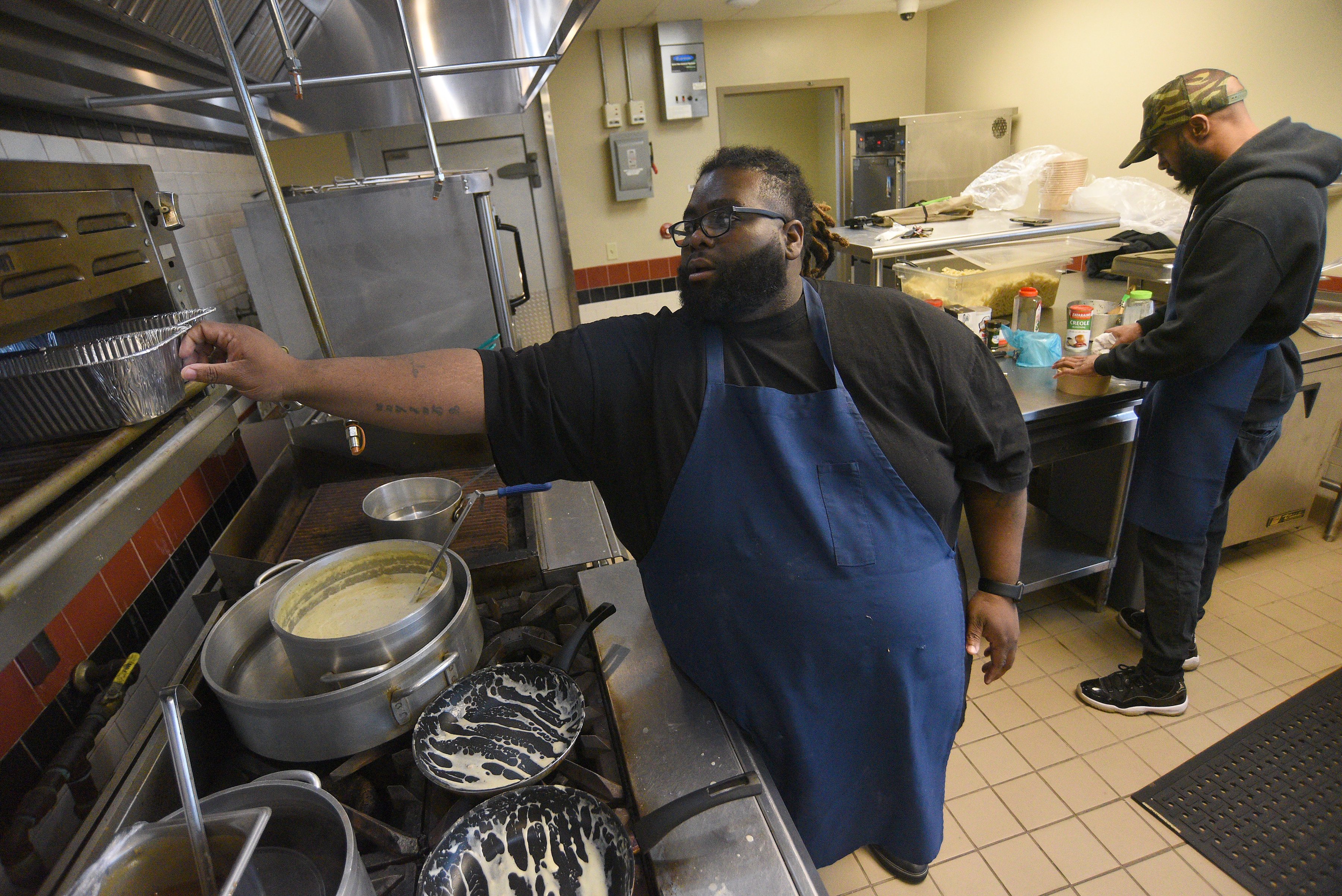 Staff Photo by Matt Hamilton / Chef Cornelius Lathan, front, works with Landas Richards at the Kitchen Incubator of Chattanooga.