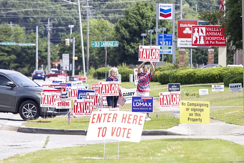 Campaign workers encourage votes for their local candidates near the Willowbrook Baptist Church polling station as Alabama votes in the state primary in Huntsville, Ala., on May 24, 2022. (AP Photo/Vasha Hunt)