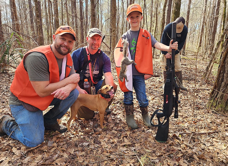 Photo contributed by Larry Case / From left, Wilson Scott, Jamie McCarson and 9-year-old Walker Scott are all smiles as they pose with Sage the squirrel hunting dog during the recent Squirrel Master Classic near Montgomery, Ala. Walker is a 4-H competitive shooter.