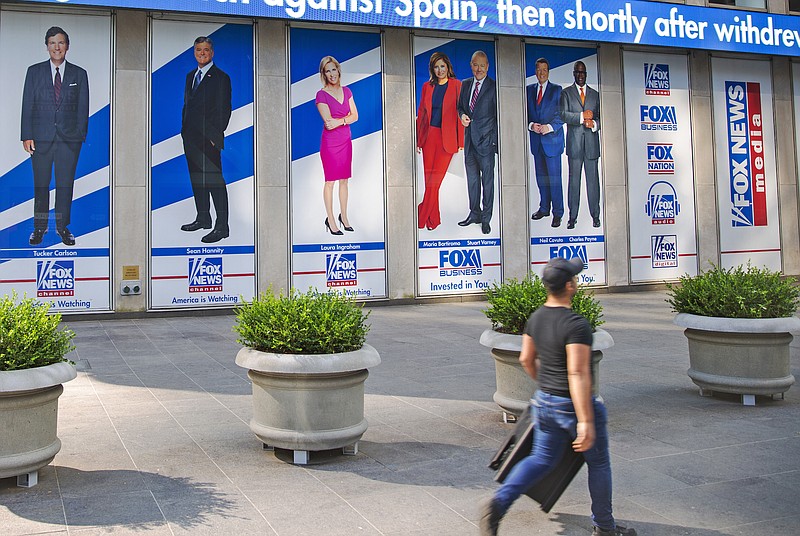 File photo/Ted Shaffrey/The Associated Press / Images of Fox News personalities, from left, Tucker Carlson, Sean Hannity, Laura Ingraham, Maria Bartiromo, Stuart Varney, Neil Cavuto and Charles Payne appear outside News Corporation headquarters in New York on July 31, 2021.