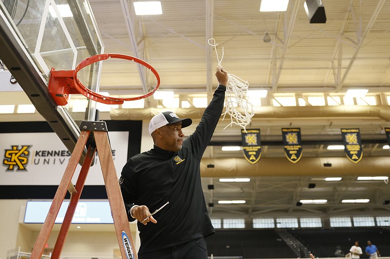Atlanta Journal-Constitution photo by Miguel Martinez via AP / Kennesaw State men's basketball coach Amir Abdur-Rahim reacts to fans as he holds the net after the Owls defeated Liberty in the ASUN Conference tournament final Sunday. With the title, the program also earned its first trip to the NCAA Division I tournament.