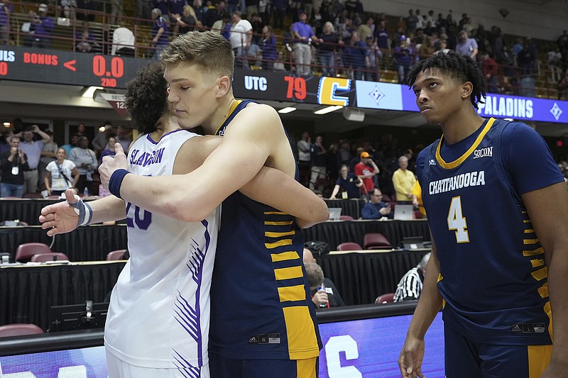 AP photo by Kathy Kmonicek / Furman forward Jalen Slawson, left, embraces UTC center Jake Stephens as forward Sam Alexis looks on after Slawson's Paladins beat the Mocs to win the SoCon tournament title Monday night in Asheville, N.C.