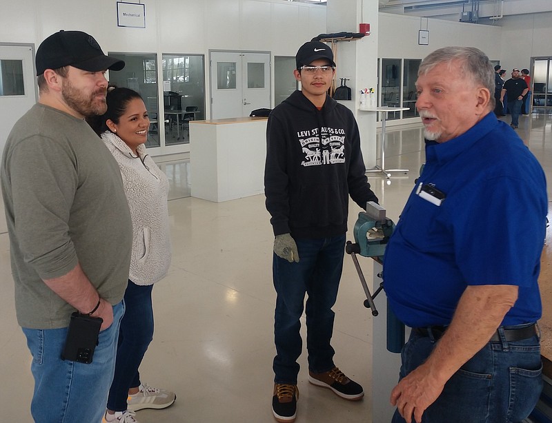 Staff Photo by Mike Pare / Ooltewah High School student Anthony Anglemyer, center, listens to Charles Beck, right, of Chattanooga State Community College, talk about programs at the Volkswagen Academy on Thursday. At left are Anthony's parents, Frank and Arianna Anglemyer.