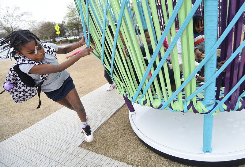 Staff photo by Matt Hamilton / Chattanooga resident A’Nieshia Jones, 7, spins other children in the interactive art installation Los Trompos on March 21 as part of Rock the Riverfront on the Chattanooga Green. While Hamilton County Schools students are on spring break, the attraction will add extra games and activities during the week and an egg hunt the Saturday before Easter.