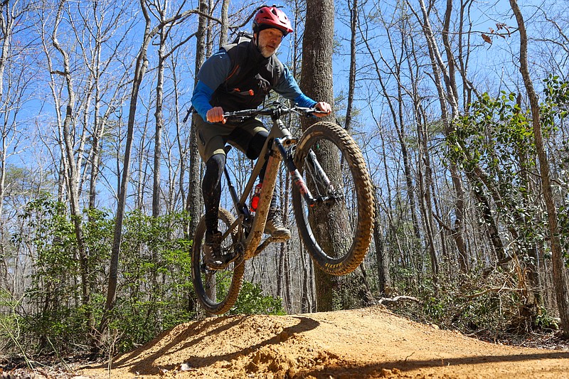 Staff Photo by Olivia Ross / Matt McLelland rides his bike over jumps along the trail. The opening of Lula Lake’s new Durham Mine Trails kicked off Saturday with a ribbon-cutting, live music, food and more.