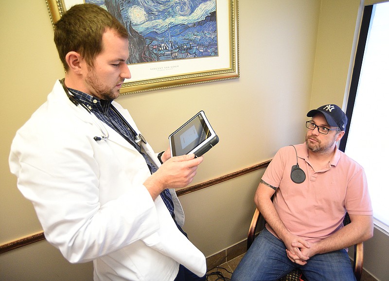 Staff Photo by Matt Hamilton / Physicians assistant Dennis Prok, left, uses a tablet to control the device implanted in the chest of Ooltewah resident James Southwick on March 21 at Advanced Center for Sleep Disorders.
