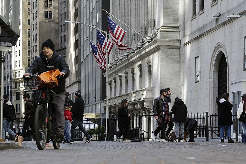 People pass the front of the New York Stock Exchange in New York, Tuesday, March 21, 2023. Stocks are rising on Wall Street, including the banks most beaten down by the industry's crisis. (AP Photo/Peter Morgan