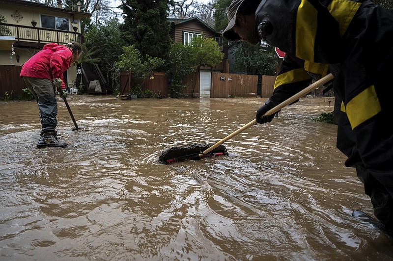 File photo/Mike Kai Chen/The New York Times / Residents move mud away from their home amid flooding caused by storms in Felton Grove, Calif., on Jan. 14, 2023. A new U.N. report says it is still possible to hold global warming to relatively safe levels, but doing so will require global cooperation, billions of dollars and big changes.