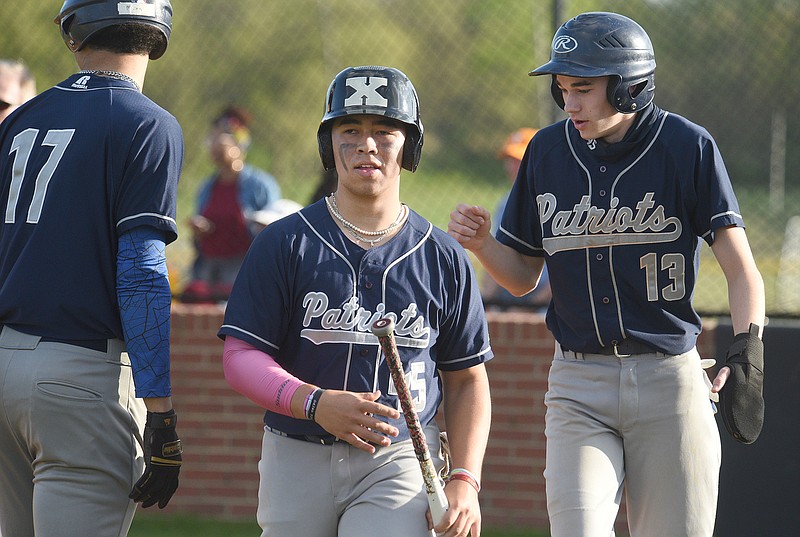 Staff photo by Matt Hamilton / Arts & Sciences teammates Ethan Porterfield, center, and Rowan Fitzsimmons (13) celebrate after scoring on Marcus Leak's double to make it 2-2 in the fourth inning of Friday's game at Howard.