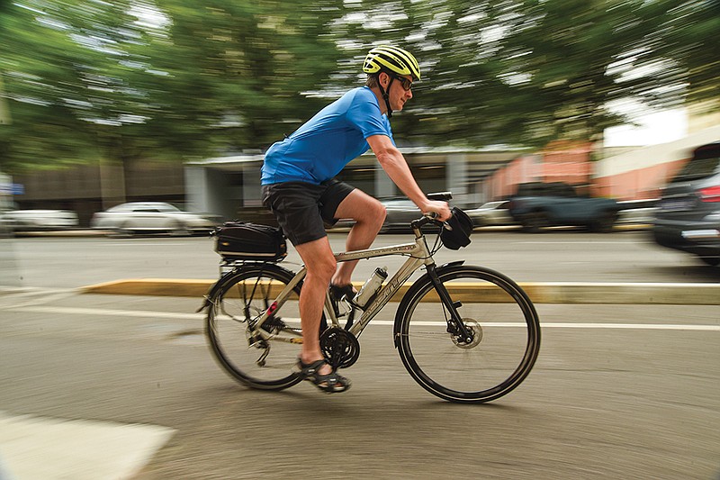 Staff photo by Matt Hamilton / Cyclist Jeffrey Cross rides along Broad Street in downtown Chattanooga.