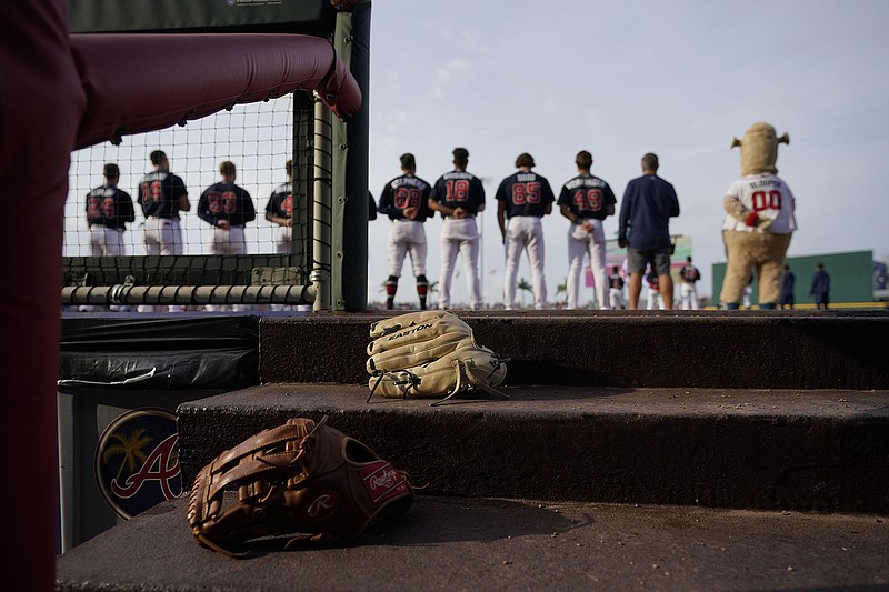 AP photo by Gerald Herbert / The Atlanta Braves line up for the national anthem before the start of a spring training exhibition game against the Philadelphia Phillies on March 18 in North Port, Fla.