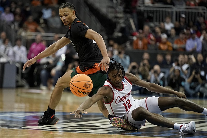 AP photo by Charlie Riedel / Houston's Tramon Mark, on court, and Miami's Isaiah Wong eye a loose ball in their NCAA tournament Midwest Region semifinal Friday in Kansas City, Mo.