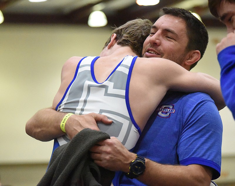 Staff photo by Matt Hamilton / Cleveland wrestler Jackson Bradford hugs head coach Joey Knox after winning the 132-pound final during the TSSAA Class AAA state traditional tournament in February 2021 at the Chattanooga Convention Center.