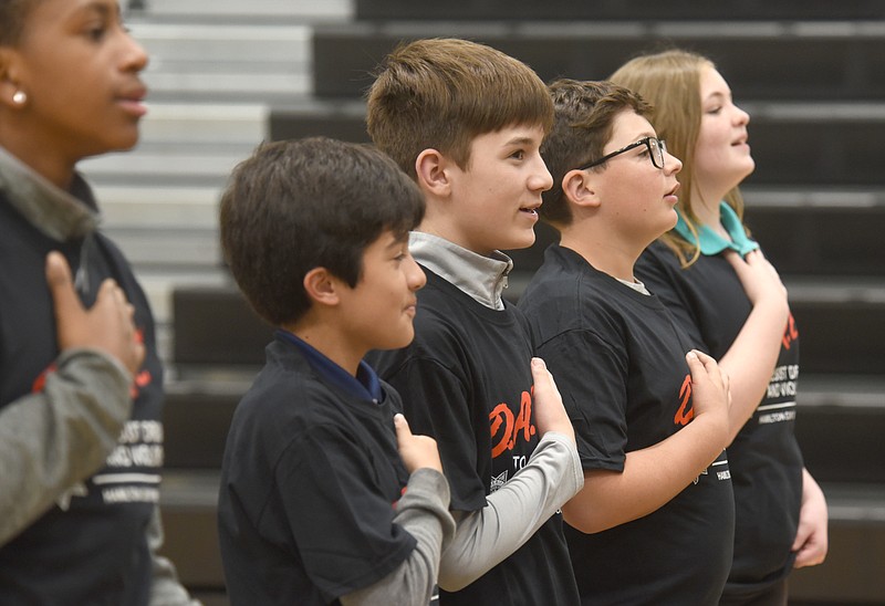 Staff photo by Matt Hamilton / DARE graduates recite the Pledge of Allegiance during their graduation ceremony at East Hamilton Middle School on Friday.