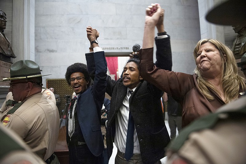 FILE - From left, Tennessee state Rep. Justin Pearson, state Rep. Justin Jones and state Rep. Gloria Johnson hold their hands up as they exit the House Chamber doors at Tennessee state Capitol Building in Nashville, Tenn., Monday, April 3, 2023. In Tennessee, three Democratic House members are facing expulsion for using a bullhorn in the House chamber to show support for pro-gun control protesters. In an increasingly polarized political atmosphere, experts say these kinds of harsh punishments for minority party members standing up for principles they believe in will likely become more common, especially when acts of civil disobedience clash with the rigid policies and procedures of legislative decorum. (Nicole Hester/The Tennessean via AP, File)