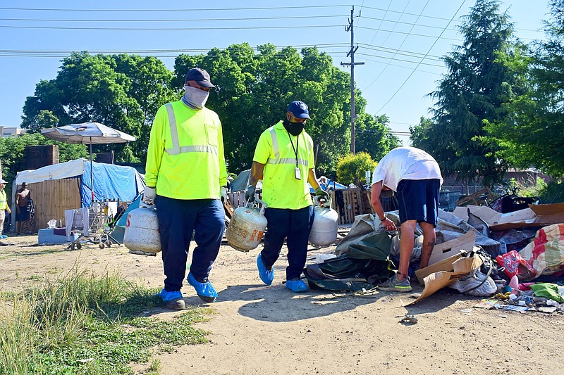 Staff Photo by Robin Rudd / City of Chattanooga Public Works employees remove recyclables and hazardous materials from the East 11th Street homeless camp on June 1 as the city prepared to close the camp and clear the property.