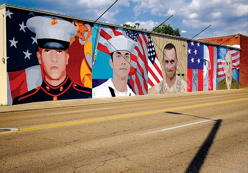 Staff file photo / Artist Kevin Bate's mural for five fallen servicemen killed in the 2015 attacks on area military facilities is seen on a building on McCallie Avenue.