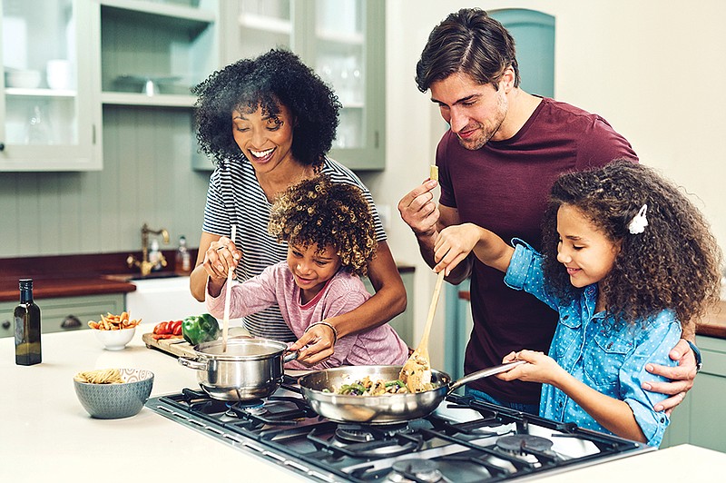 Getty Images / Families can strengthen their bonds by cooking together, as well as making time for meals together.