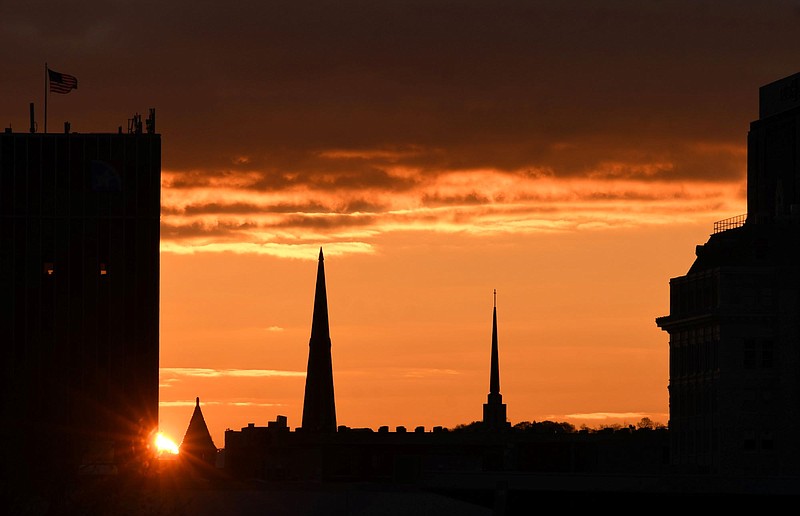 Staff Photo by Robin Rudd / The rising sun peeks between church steeples in Chattanooga on March 14.