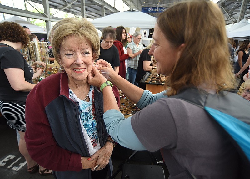 Staff Photo by Matt Hamilton / Chattanooga resident Mimi Grine, right, helps her mother, Norma Hoehndorf, of Florida, put on earrings purchased from a vendor during a Mother's Day celebration at Chattanooga Market in First Horizon Pavilion in 2022.