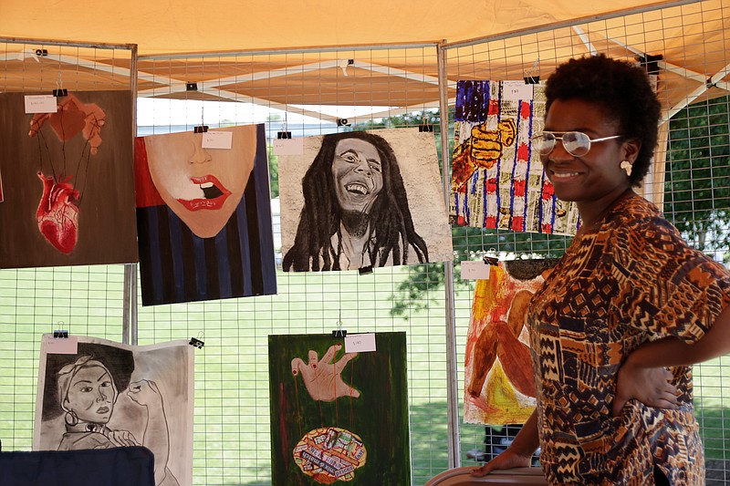 Staff Photo / Michelle Gore stands in front of her paintings at her booth during the inaugural Chattanooga Festival of Black Arts and Ideas outside the Chattanooga Theater Centre in 2018. The festival featured live music and showcased a range of work from black artists.