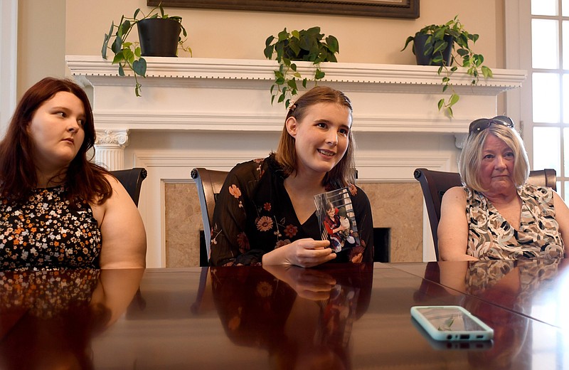 Staff Photo by Robin Rudd / Andrea White, center, shows a photo of her son, Oliver Hudson, being held by her mother, Carol Rene White, while she talks about missing her. Her sister, Samantha, left, and grandmother, Donna White, listen. The family of Carol Rene White spoke with the Chattanooga Times Free Press at the law offices of Davis and Hoss in Fort Wood on Aug. 2.