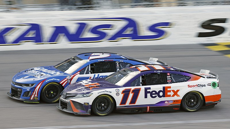 AP photo by Colin E. Braley / Denny Hamlin (11) and Kyle Larson head down the front stretch at Kansas Speedway as they battle for the lead during Sunday's NASCAR Cup Series race. Hamlin used a last-lap move to finally pass Larson and win the race.