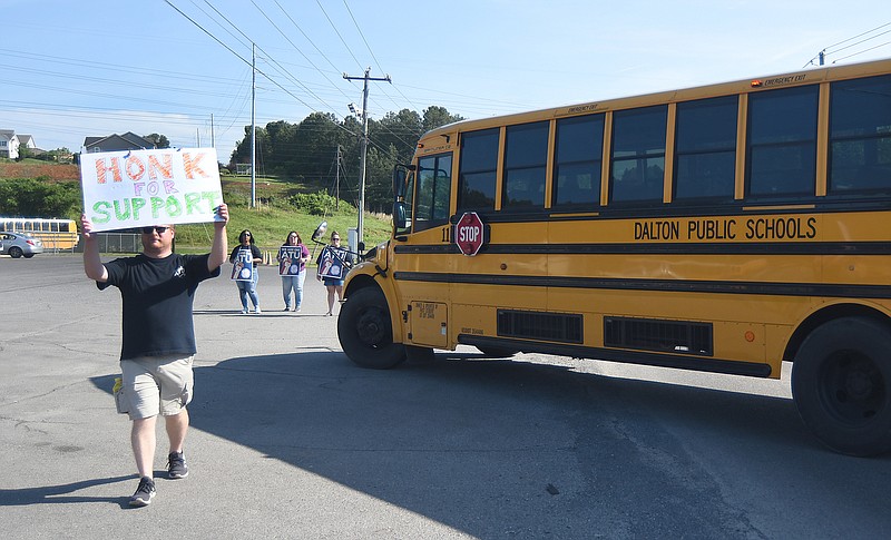 Staff photo by Matt Hamilton / Tyler Minchew carries a sign during the protest by Amalgamated Transit Union Local 1212 in front of First Student in Dalton, Ga., on Monday.