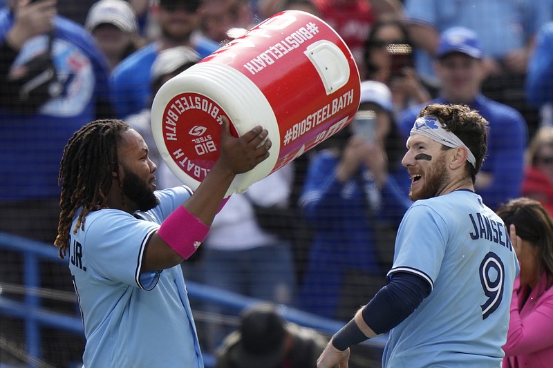 Toronto Blue Jays' Danny Jansen (9) celebrates with teammate Vladimir Guerrero Jr, left, after hitting a winning two-run single against the Atlanta Braves during ninth-inning baseball game action in Toronto, Ontario, Sunday, May 14, 2023. (Frank Gunn/The Canadian Press via AP)