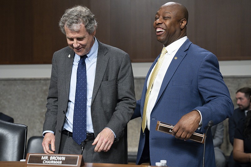 Chairman of the Senate Banking, Housing, and Urban Affairs committee, Sen. Sherrod Brown, D-Ohio, left, and Ranking Member Sen. Tim Scott, R-S.C., arrives for a hearing examining the failures of Silicon Valley Bank and Signature Bank, Tuesday, May 16, 2023, on Capitol Hill in Washington. (AP Photo/Jacquelyn Martin)