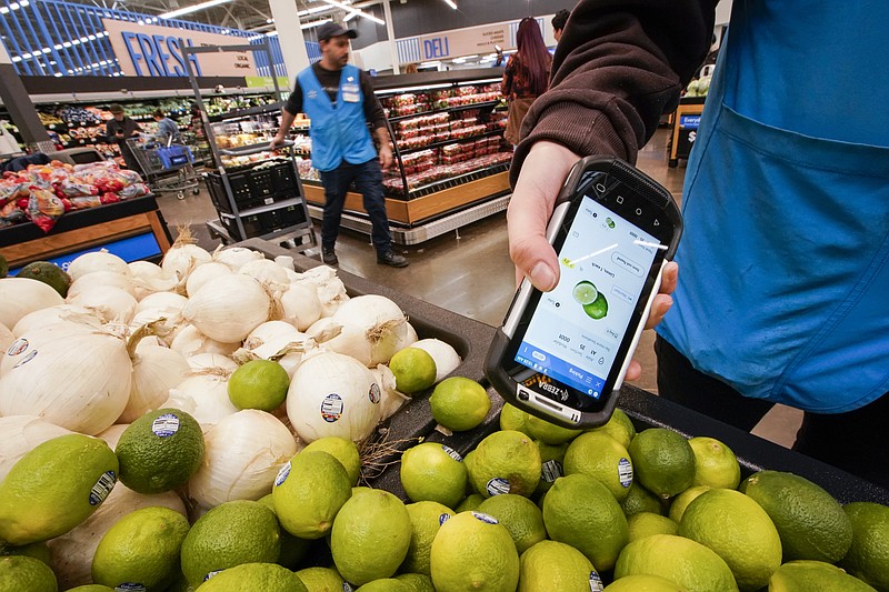 FILE - A worker scans onions, limes and other produce inside the Walmart Supercenter in North Bergen, Thursday, Feb. 9, 2023, in New Jersey. Walmart reported a strong first quarter, Thursday, May 18,  and boosted its outlook for the year as the nations largest retailer continues to draw budget conscious consumers in a challenging economic environment. (AP Photo/Eduardo Munoz Alvarez, File)