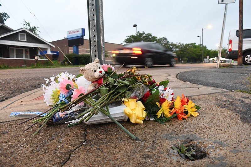 Staff Photo by Robin Rudd / A makeshift memorial sits June 7 at the base of a street sign outside Mary's Bar and Grill at 2125 McCallie Ave., in Chattanooga. Three people were killed and 14 others wounded and injured after a shooting in the early morning June 5.