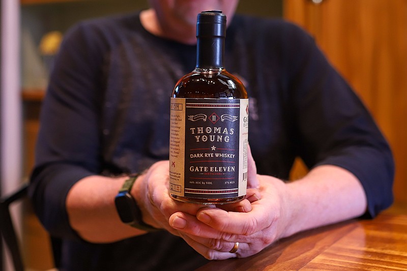 Staff photo by Olivia Ross / Bill Lee of Gate 11 Distillery holds the new Thomas Young dark rye whiskey on Thursday.