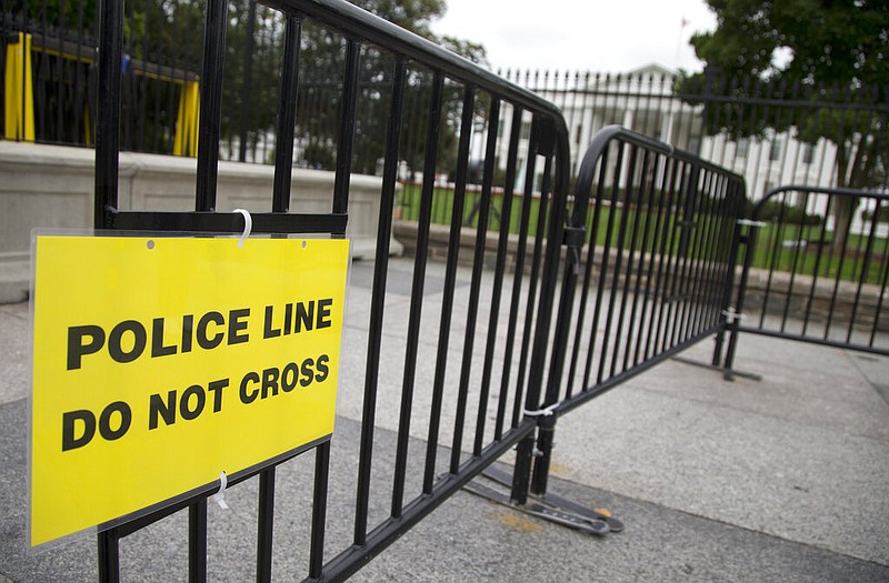 FILE - In this Oct. 3, 2014, file photo, a temporary barrier marked with a sign "Police Line Do Not Cross" is seen along Pennsylvania Avenue in front of the White House in Washington. The Secret Service has placed a high-ranking supervisor on administrative leave and suspended the supervisor's security clearance after what it calls "allegations of misconduct and potential criminal activity." (AP Photo/Carolyn Kaster, File)