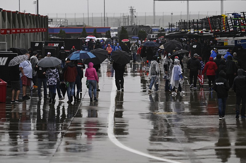 AP photo by Matt Kelley / NASCAR fans walk through the garage area at Charlotte Motor Speedway on Sunday in Concord, N.C. The Coca-Cola 600, the longest race on the Cup Series schedule, was set to take place that evening but was postponed to Monday because of wet weather.