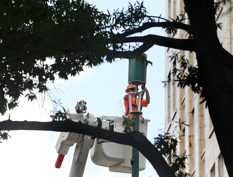 Staff file photo / An equipment operator works on increasing data on certain cellphone towers in the downtown Chattanooga area in August 2019.