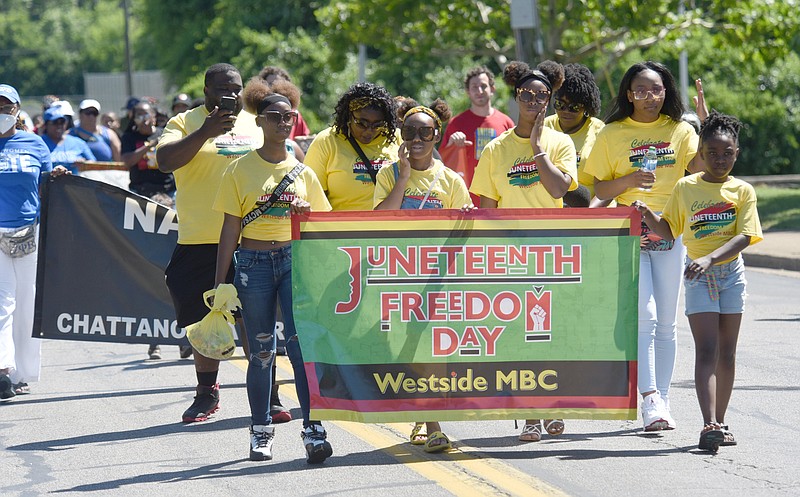 Staff Photo by Matt Hamilton / Parishioners from Westside Missionary Baptist Church carry a banner in the inaugural Juneteenth National Freedom Day Parade on North Orchard Knob Avenue in 2022.