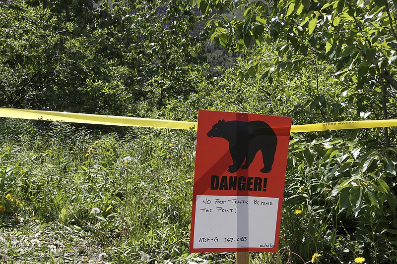 AP photo by Mark Thiessen / A warning sign and police tape mark a boundary in the vicinity of a bear attack in June 2018 near Anchorage, Alaska's largest city.