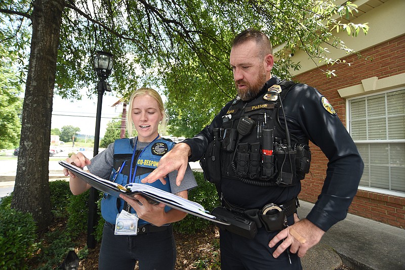 Staff photo by Matt Hamilton/ Officer Brandon Watson and clinical social worker Rachel Smith talk after responding to a call in Hixson on July 10.