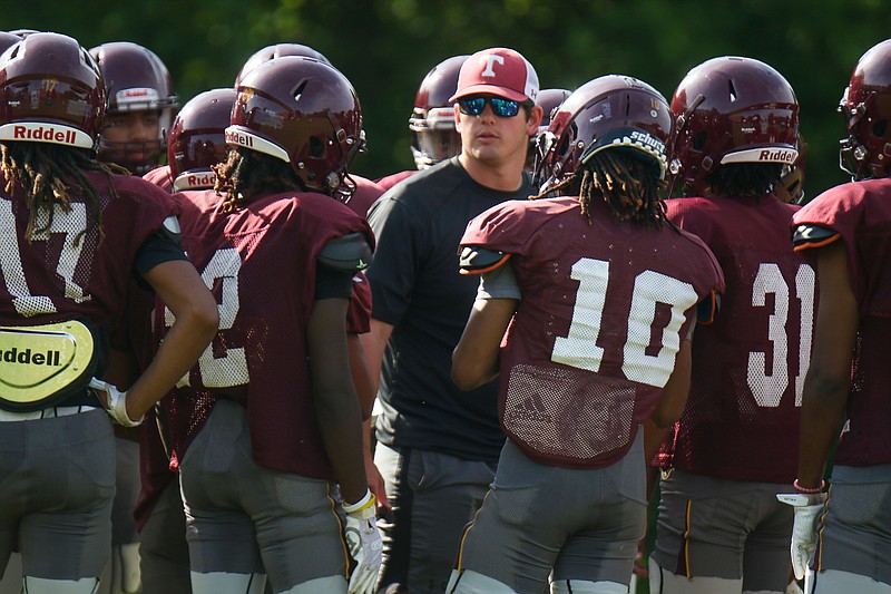 Staff photo by Olivia Ross / Tyner football coach Christian Mainor, who was promoted in the offseason after serving as offensive coordinator last year when the Rams won a state championship, talks to his players during a May practice.