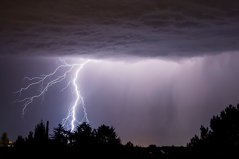 Getty Images / A powerful bolt of lightning strikes over the night sky.
