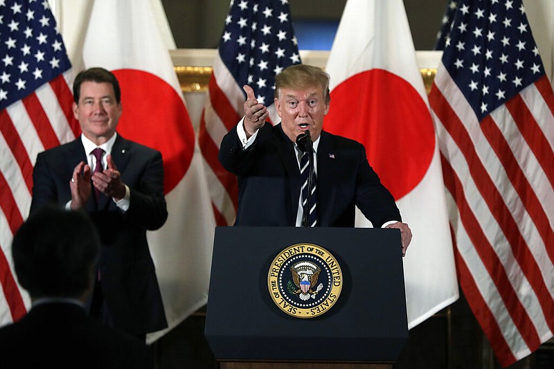 Then-President Donald Trump speaks with Japanese business leaders, Saturday, May 25, 2019, in Tokyo, as then-Ambassador to Japan William Hagerty listens. (AP Photo/Evan Vucci)