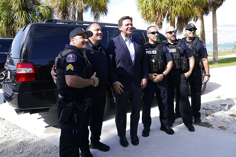 Florida Gov. Ron DeSantis poses with law enforcement officials after a news conference at Bill Baggs Cape Florida State Park , Thursday, Dec. 1, 2022, on Key Biscayne, Fla. (AP Photo/Lynne Sladky)