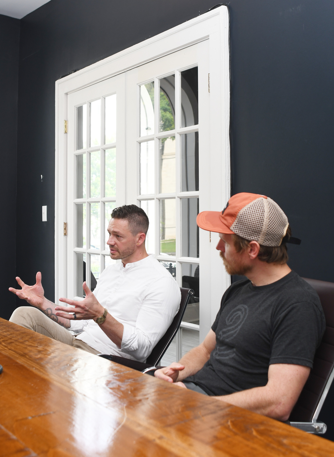 Staff Photo by Robin Rudd / Chief Strategy Officer C. Elliott Johnston, left, talks about the progress of Triptych as partner and Chief Technical Officer Tyler Johnson listens at the company's Georgia Avenue offices on Aug. 8.