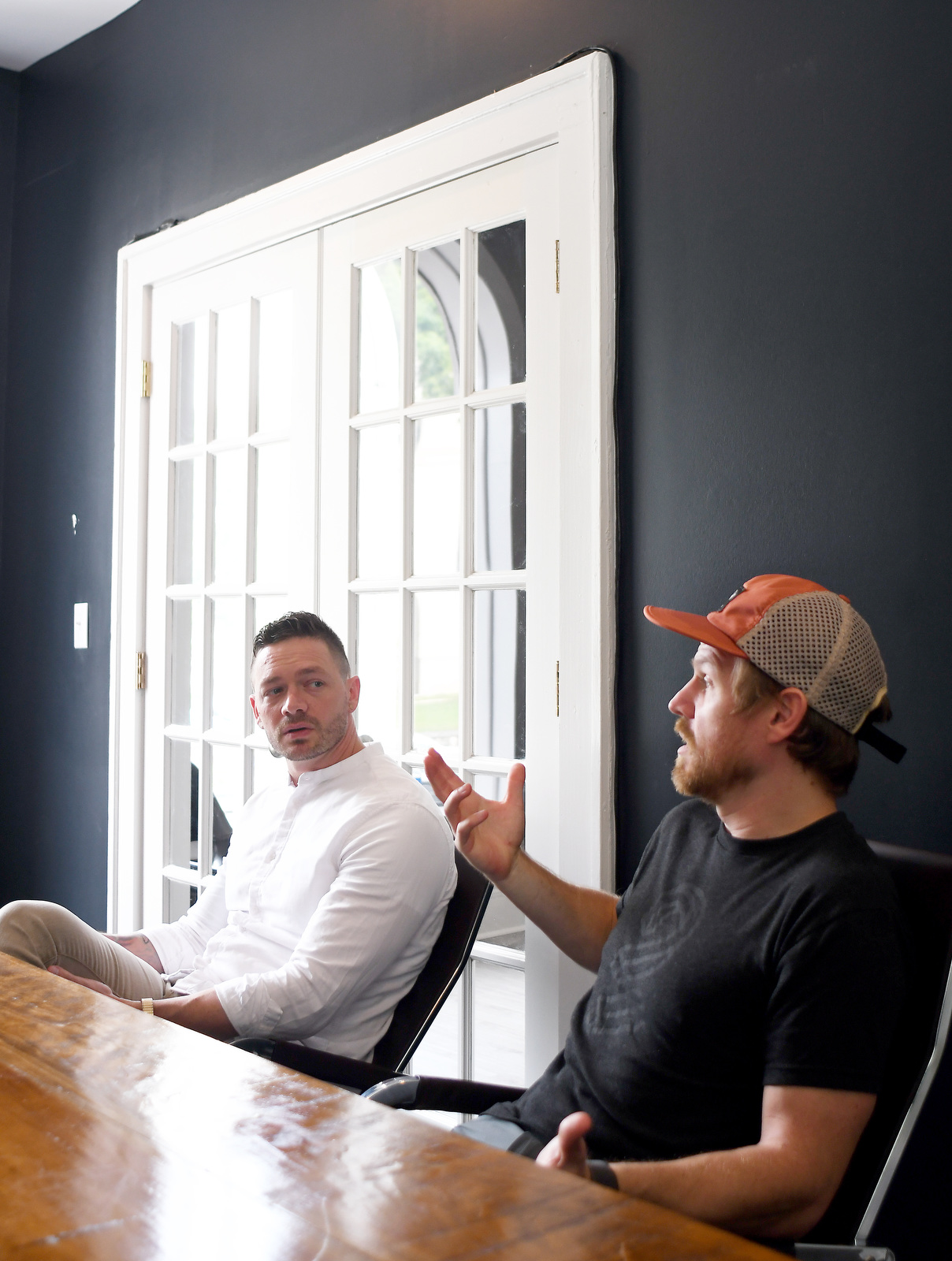 Staff Photo by Robin Rudd / Chief Technical Officer Tyler Johnson, right, talks about the history of Triptych, as Chief Strategy Officer C. Elliott Johnston looks on at the company's Georgia Avenue offices on Aug. 8.